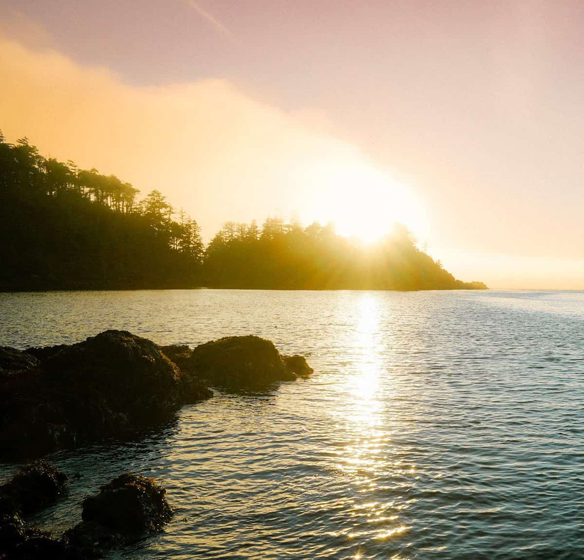 Looking out over rocky shoreline during sunset at Terrace Beach, a family friendly beach close to Tofino and Ucluelet.